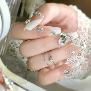 Sparkling rhinestone detail on nude white French press-on nail