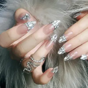 Detailed view of full crystal French tip on nude stiletto press-on nail