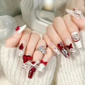 Close-up of red white heart bow press-on nails on hand