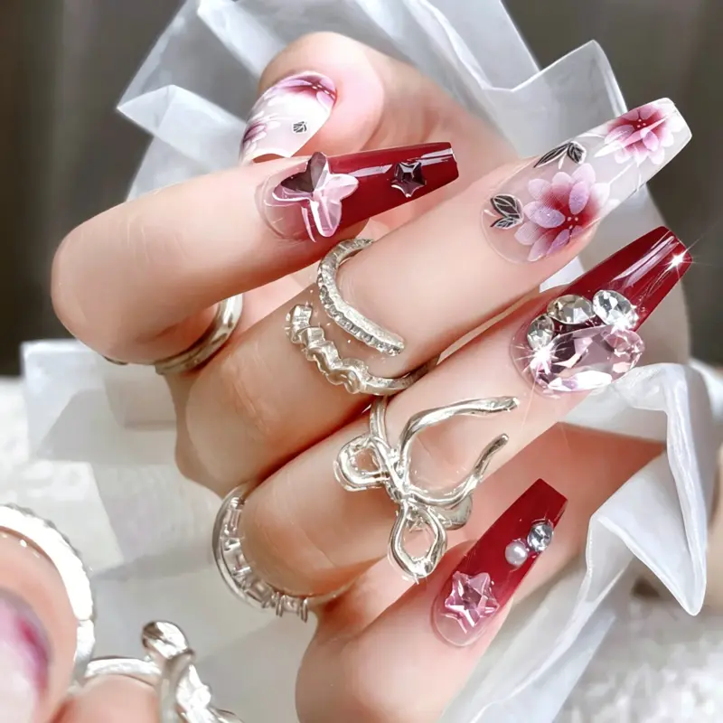 Detailed View Of Hand Painted Pink Flowers On Burgundy Nails