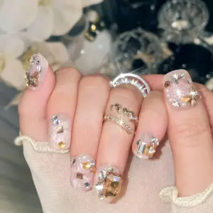 Detailed View Of Multi Shaped Rhinestones On Clear Glitter Nails