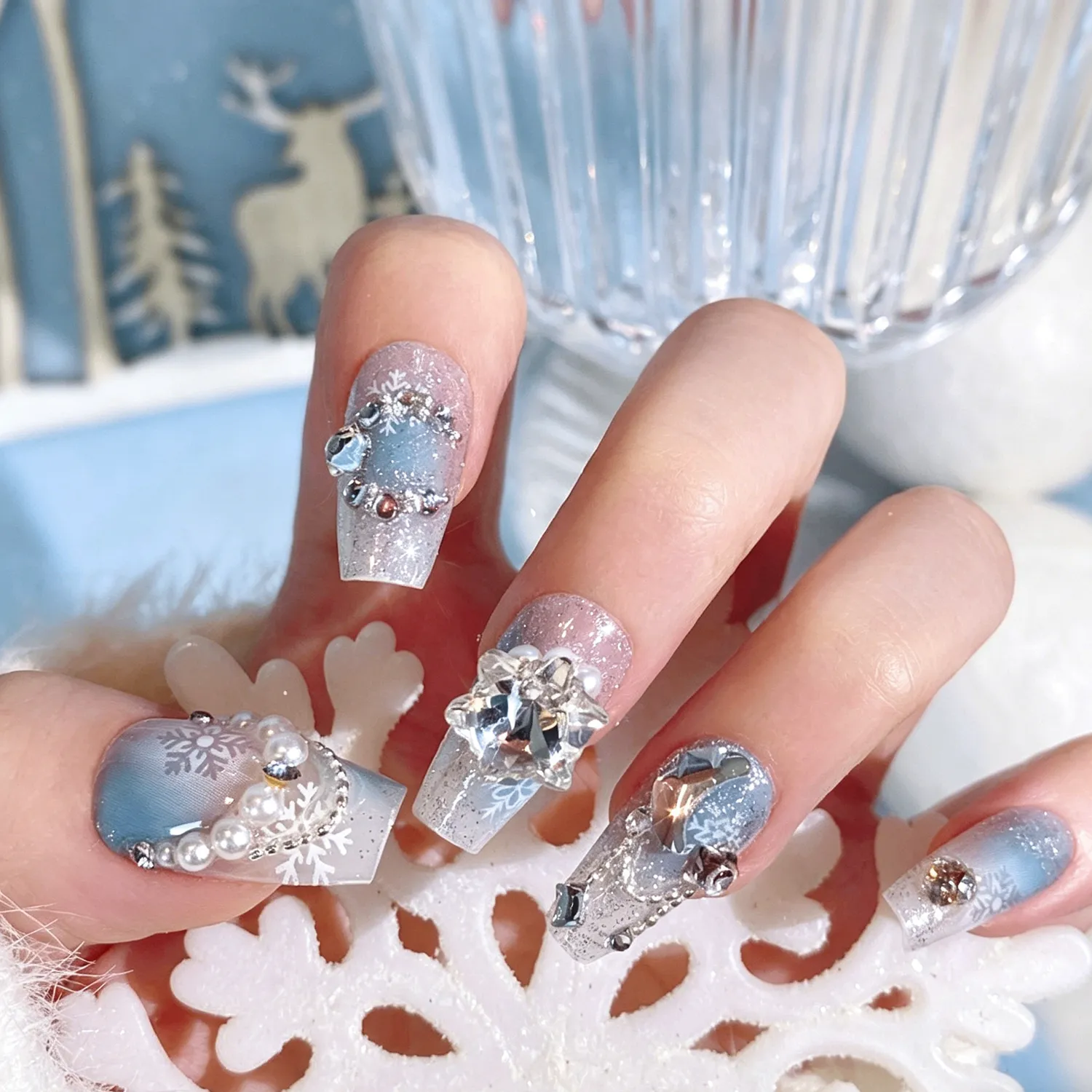 Hand wearing Christmas snowflake rhinestone press-on nails, full size