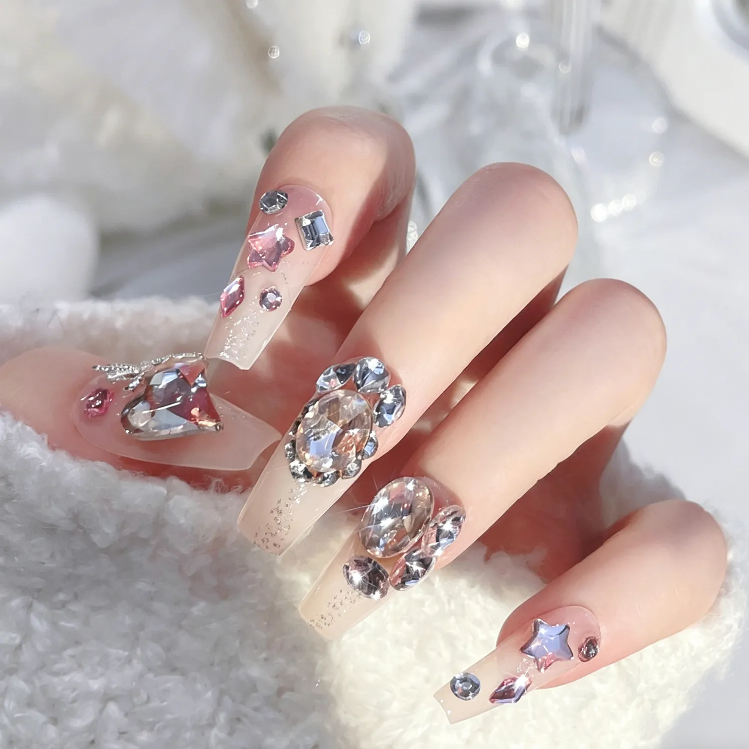 Hand wearing premium shiny rhinestone nails, large gems sparkle